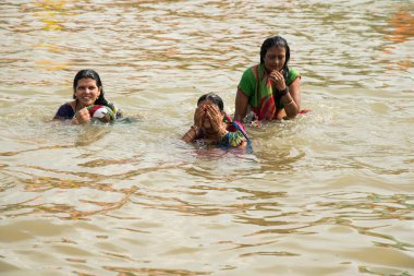 NASHIK, INDIA  29 AUGUST 2015 : Devotees take a holy bath at the in the river during the Simhastha Kumbh Mela. clipart