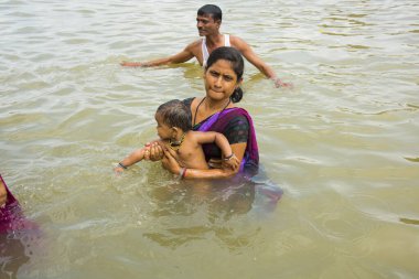 NASHIK, INDIA  29 AUGUST 2015 : Devotees take a holy bath at the in the river during the Simhastha Kumbh Mela. clipart