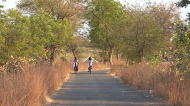 AMRAVATI, INDIA, 24 Mart 2025: Okula gitmek için bisiklete binen kız.