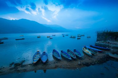 Fewa Gölü, Pokhara, Nepal 'de renkli ahşap tekne..