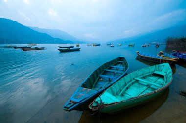 Fewa Gölü, Pokhara, Nepal 'de renkli ahşap tekne..
