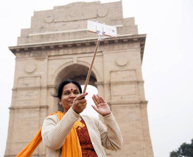 Hindistan Kapısı, Delhi, Hindistan önünde akıllı telefonuyla selfie çeken bir turist..