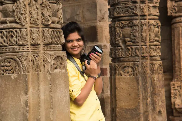 Qutub Minar, Delhi, Hindistan 'da DSLR kameralı genç kadın fotoğrafçı..