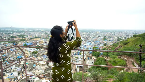 Jodhpur 'da kamerası olan genç bir kadının portresi. Hindistan' ın mavi şehri.