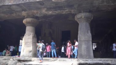 MUMBAI, MAHARASHTRA, INDIA, 9 Aralık 2024: UNESCO Dünya Mirası Sitesi, Fil Mağaraları 'nın mimarisi ve heykeline bakan turist.