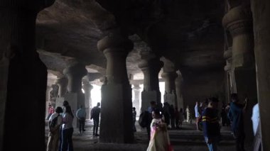 MUMBAI, MAHARASHTRA, INDIA, 9 Aralık 2024: UNESCO Dünya Mirası Sitesi, Fil Mağaraları 'nın mimarisi ve heykeline bakan turist.