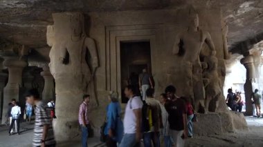 MUMBAI, MAHARASHTRA, INDIA, 9 Aralık 2024: UNESCO Dünya Mirası Sitesi, Fil Mağaraları 'nın mimarisi ve heykeline bakan turist.