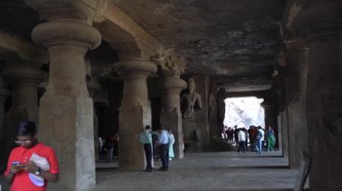 MUMBAI, MAHARASHTRA, INDIA, 9 Aralık 2024: UNESCO Dünya Mirası Sitesi, Fil Mağaraları 'nın mimarisi ve heykeline bakan turist.