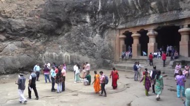 MUMBAI, MAHARASHTRA, INDIA, 9 Aralık 2024: UNESCO Dünya Mirası Sitesi, Fil Mağaraları 'nın mimarisi ve heykeline bakan turist.