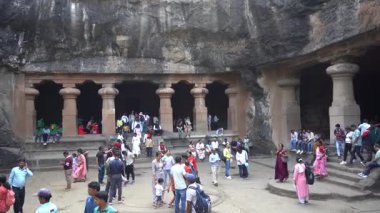 MUMBAI, MAHARASHTRA, INDIA, 9 Aralık 2024: UNESCO Dünya Mirası Sitesi, Fil Mağaraları 'nın mimarisi ve heykeline bakan turist.