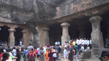 MUMBAI, MAHARASHTRA, INDIA, 9 Aralık 2024: UNESCO Dünya Mirası Sitesi, Fil Mağaraları 'nın mimarisi ve heykeline bakan turist.