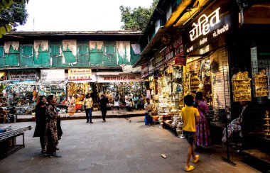 PUNE, INDIA, 25 Aralık 2024: Tulshi Baug Market 'te alışveriş için toplanan kalabalık, geleneksel Maharashtrian yemek malzemeleri, kozmetik ürünleri, mücevher ve ev eşyaları da dahil olmak üzere ürünler satıyor.