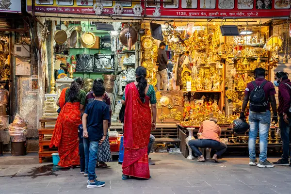 PUNE, INDIA, 25 Aralık 2024: Tulshi Baug Market 'te alışveriş için toplanan kalabalık, geleneksel Maharashtrian yemek malzemeleri, kozmetik ürünleri, mücevher ve ev eşyaları da dahil olmak üzere ürünler satıyor.