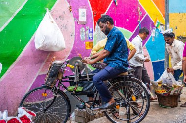 MUMBAI, INDIA, 28 Aralık 2024: Demirci, Dadar İstasyonu yakınlarındaki çiçek pazarında bir bıçağı bilemek için disk makinesi kullanıyor.