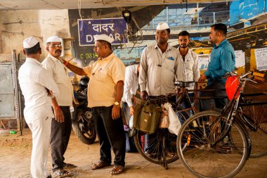 MUMBAI, INDIA, 28 Aralık 2024: Dadar istasyonunda birbiriyle konuşan Dabbawallas