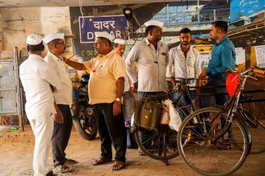 MUMBAI, INDIA, 28 Aralık 2024: Dadar istasyonunda birbiriyle konuşan Dabbawallas