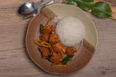 Kızarmış domuz pirzolası, köri ezmesi ve pilav.