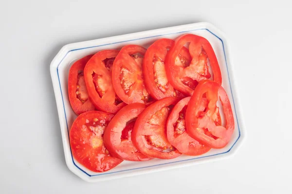 stock image sliced tomatoes in a plate on a white background