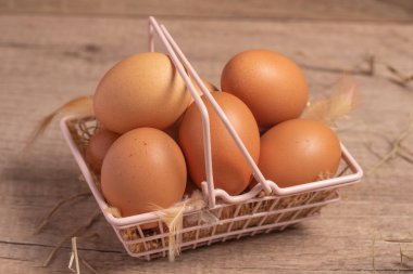 Tahta bir arka planda sepetteki taze yumurtalar. Boşluğu kopyala..