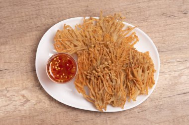 Bol yağda kızartılmış altın iğneli mantar, tatlı ve baharatlı sos.