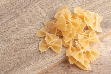 Ahşap arka planda çiğ makarna.