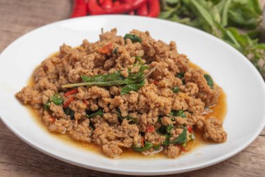 Pad kaprao, tahtadan arka planda beyaz tabakta doğranmış tavuk.