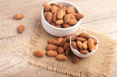 Beyaz bardakta tuzlanmış badem. Boşluğu kopyala.