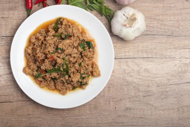 Pad kaprao, tahtadan arka planda beyaz tabakta doğranmış tavuk.