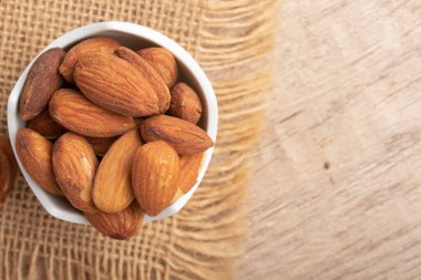 Beyaz bardakta tuzlanmış badem. Boşluğu kopyala.