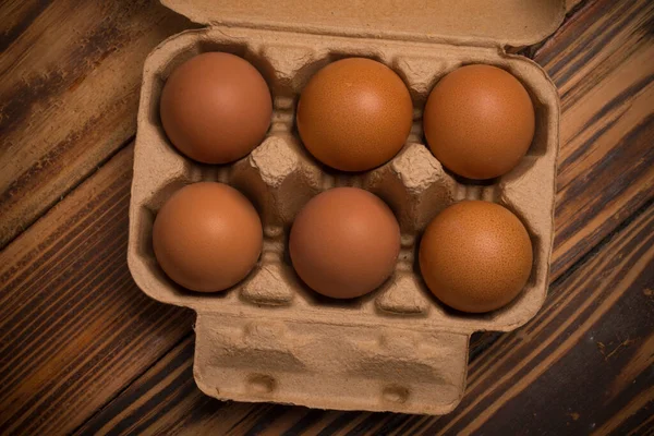 Fresh chicken eggs in cardboard boxes on wooden background