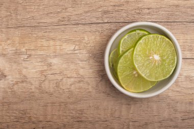 Tahta arka planda dilimlenmiş limonlar.