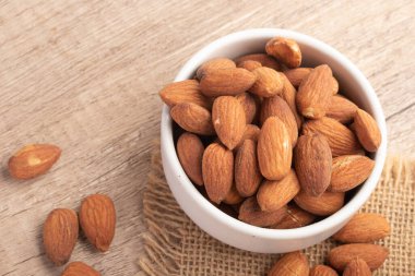 Beyaz bardakta tuzlanmış badem. Boşluğu kopyala.