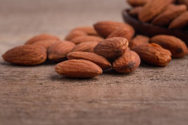 Salted almonds in wooden spoon on wooden background