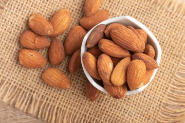 Beyaz bardakta tuzlanmış badem. Boşluğu kopyala.