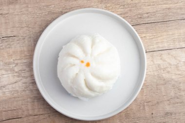 Steamed pork buns in a plate on a white background