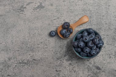 Raw Organic Blueberries in a Bowl on a gray background,
