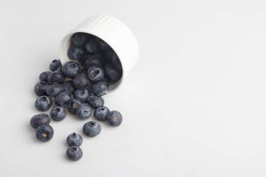 beyaz zemin üzerine bir bardak yaban mersini