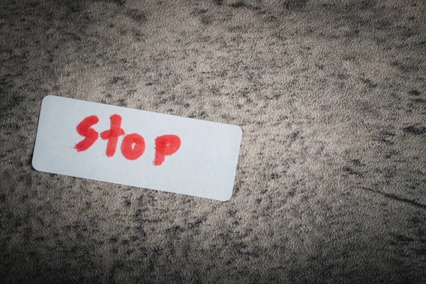 a piece of paper after writing the word 'STOP'.
