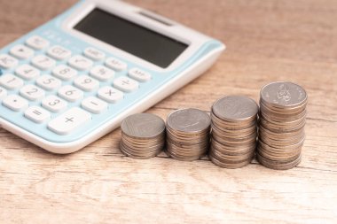 Money with calculator on brown background.Cost calculation concept.