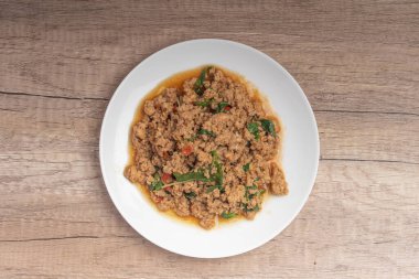 Pad kaprao, tahtadan arka planda beyaz tabakta doğranmış tavuk.