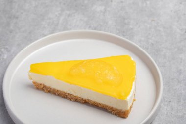 Beyaz tabakta üçlü limonlu cheesecake.