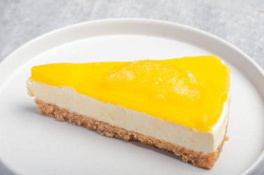 Beyaz tabakta üçlü limonlu cheesecake.