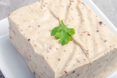 Siyah susamlı tofu taneleri beyaz tabakta tofu.