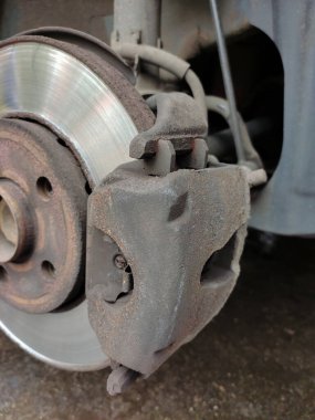 Ön araba diski silinmiş tekerlek ve eskimiş fren yastığı yakın çekim