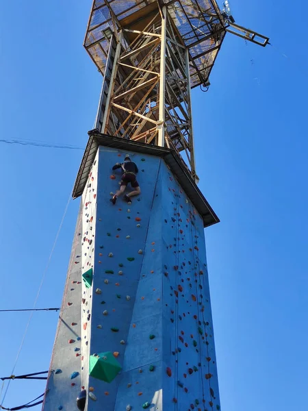 Chłopiec Wdrapuje Się Wysoką Wieżę Ścianami Wspinaczkowymi Hakach Specjalnym Wyposażeniu — Zdjęcie stockowe