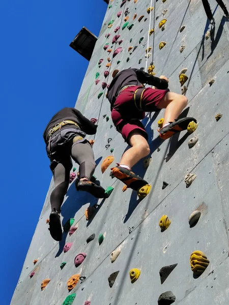 2人の男性選手がロープを登るために壁にプルアップで競います 通りに壁がある 下からの眺め — ストック写真