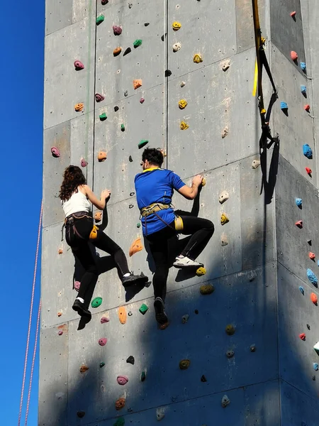 男の子と女の子は特別な機器でフックを登るために壁に競合します 通りに壁がある 下からの眺め — ストック写真