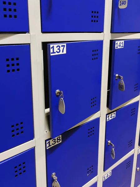Blue lockers in a public changing room or in a clothing store. A storage room in a supermarket. Some of the doors are open