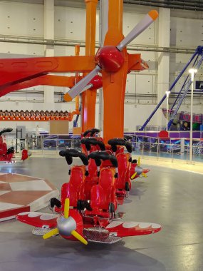 Eğlence parkında iki koltuklu ve pervaneli bir çizgi film uçağı şeklinde boş bir atlıkarınca.