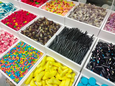 Çeşitli renk ve şekillerde şekerler mağazadaki ayrı satış tepsilerinde satılıktır. Yukarıdan görüntüle